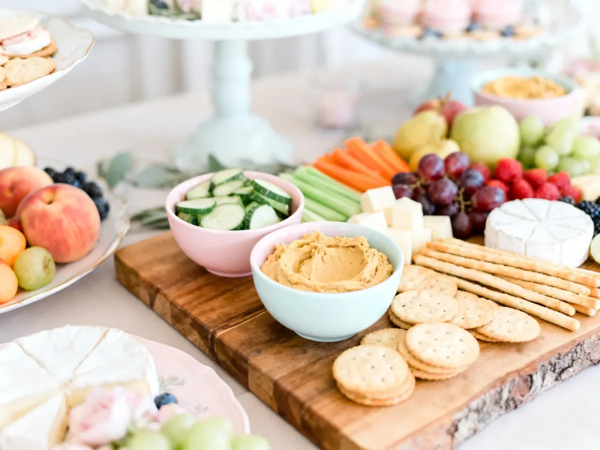 Pastelowy stół z różnorodnymi przekąskami na baby shower